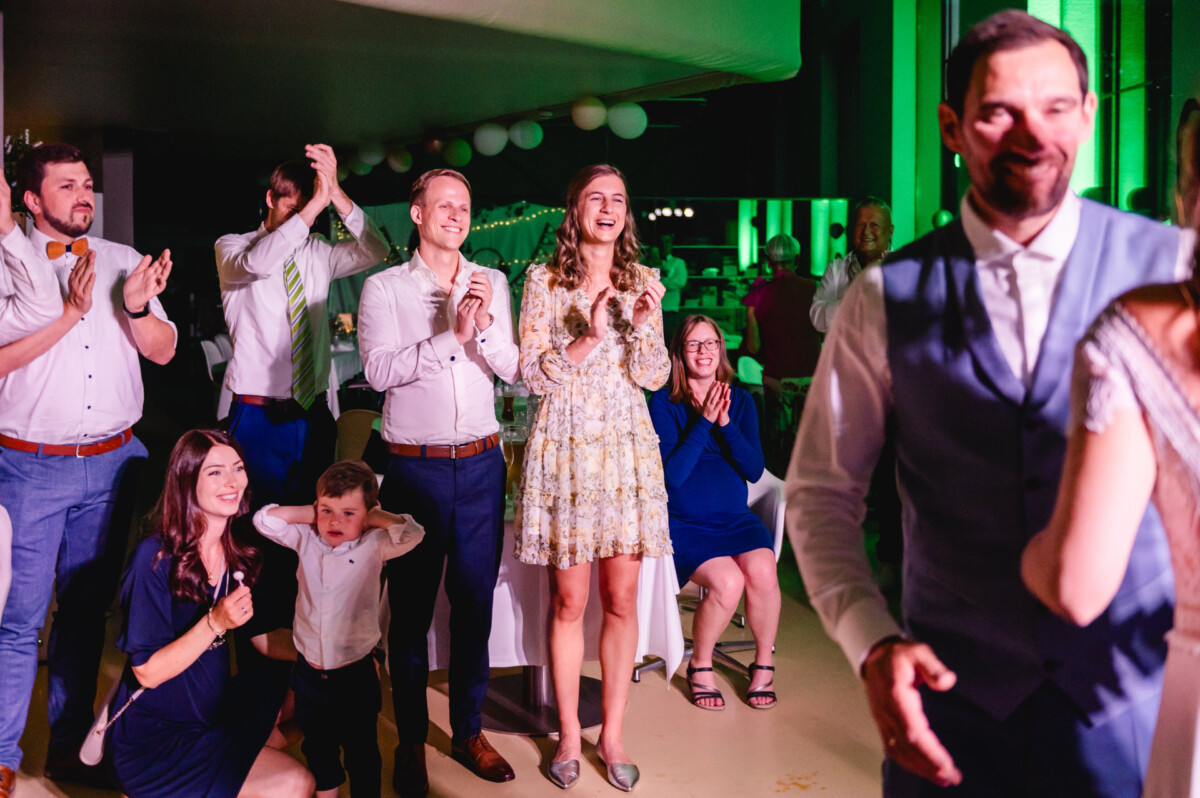 Eine Gruppe von Menschen klatscht bei einer Hochzeitsfeier.