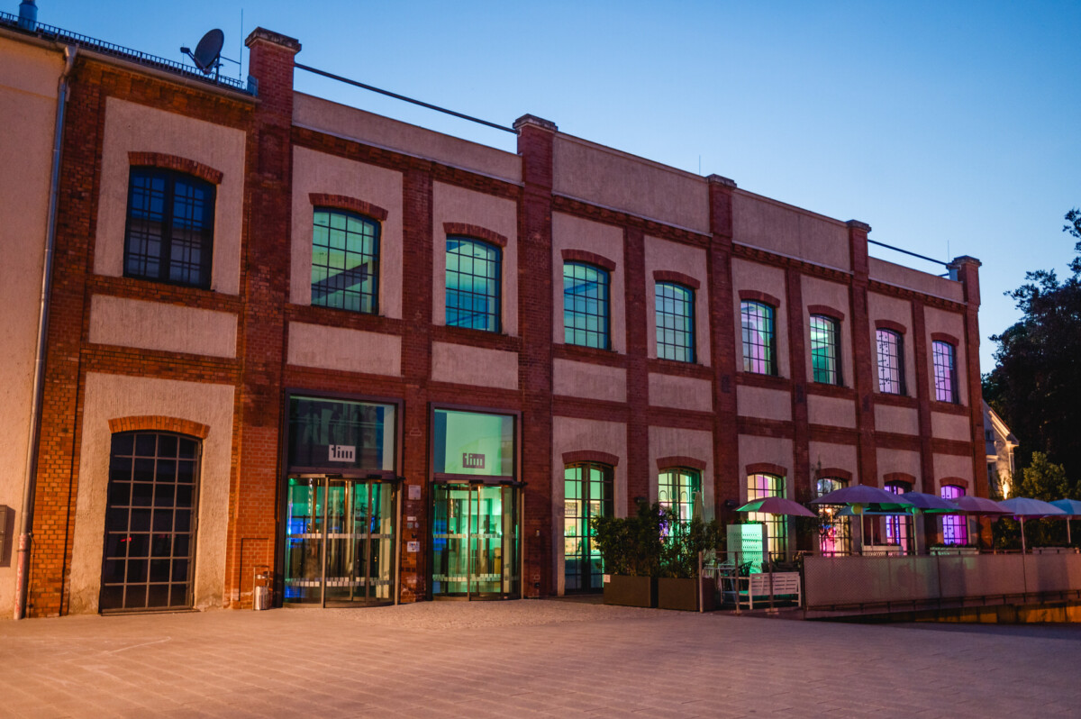 Ein Backsteingebäude mit in der Abenddämmerung beleuchteten Fenstern.