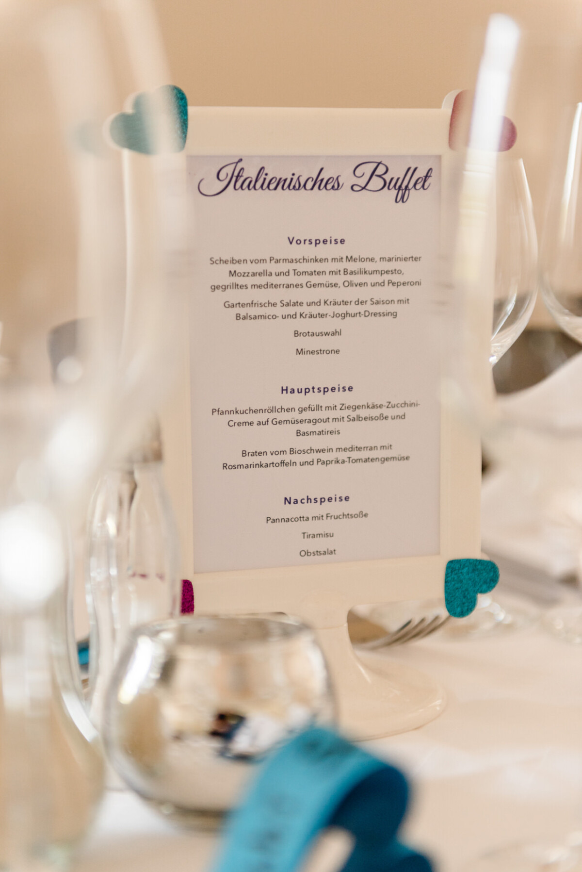 Menükarte mit dem Titel „Italienisches Buffet“ zwischen Geschirr und Dekoration platziert.