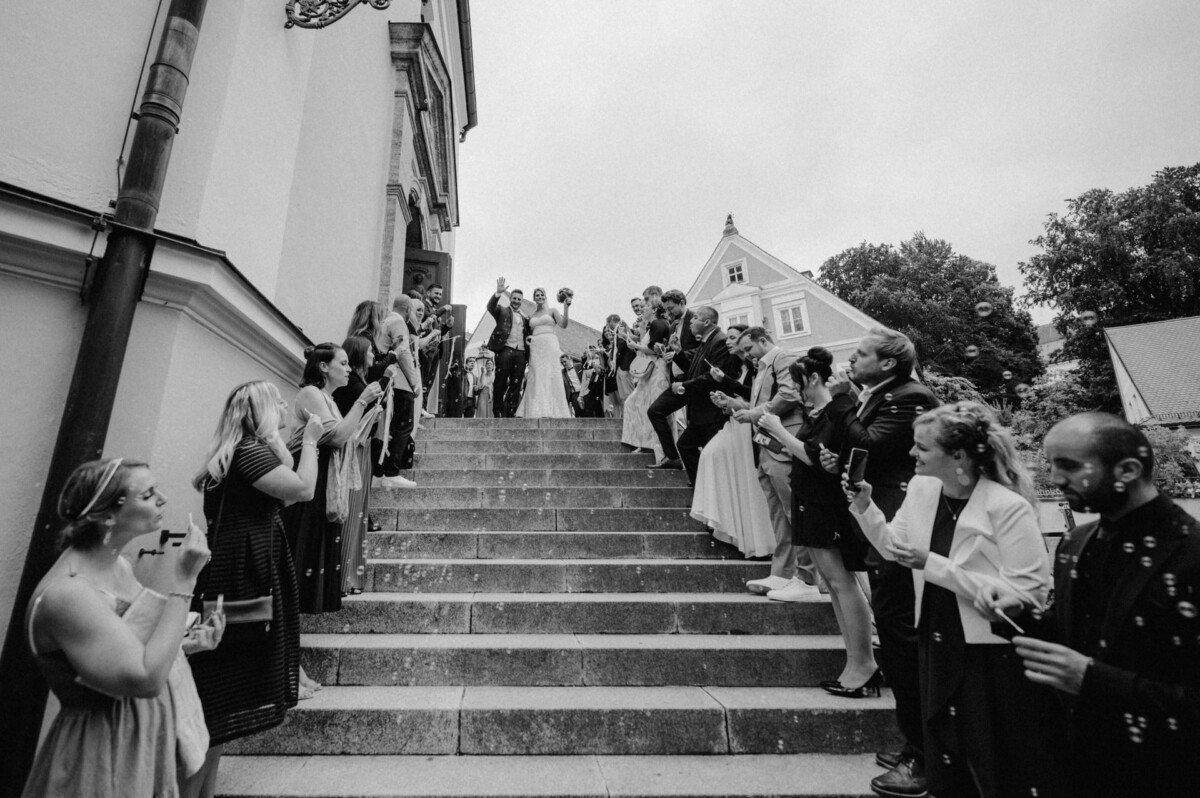 christian-lorenz.net Frischvermählte und Hochzeitsgesellschaft posieren für Fotos auf einer Treppe, während sich auf beiden Seiten Gäste mit Wunderkerzen in der Hand versammelt haben.