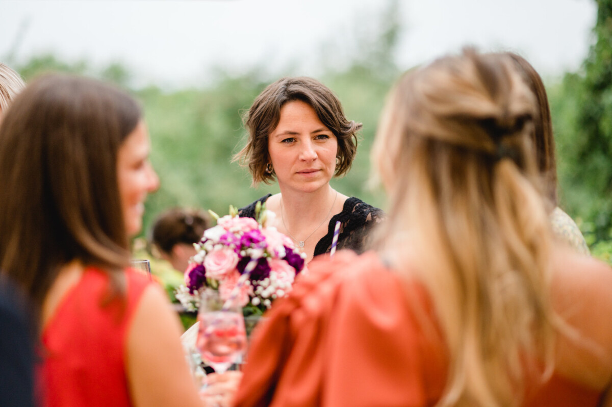 christian-lorenz.net Eine Frau mit einem Blumenstrauß unterhält sich im Freien mit drei anderen.