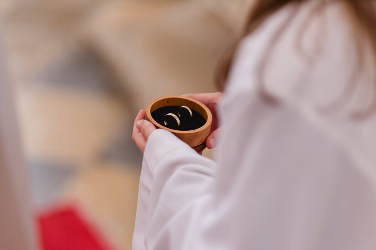 christian-lorenz.net Eine Person in einem weißen Gewand hält eine kleine Holzschale mit zwei goldenen Ringen.