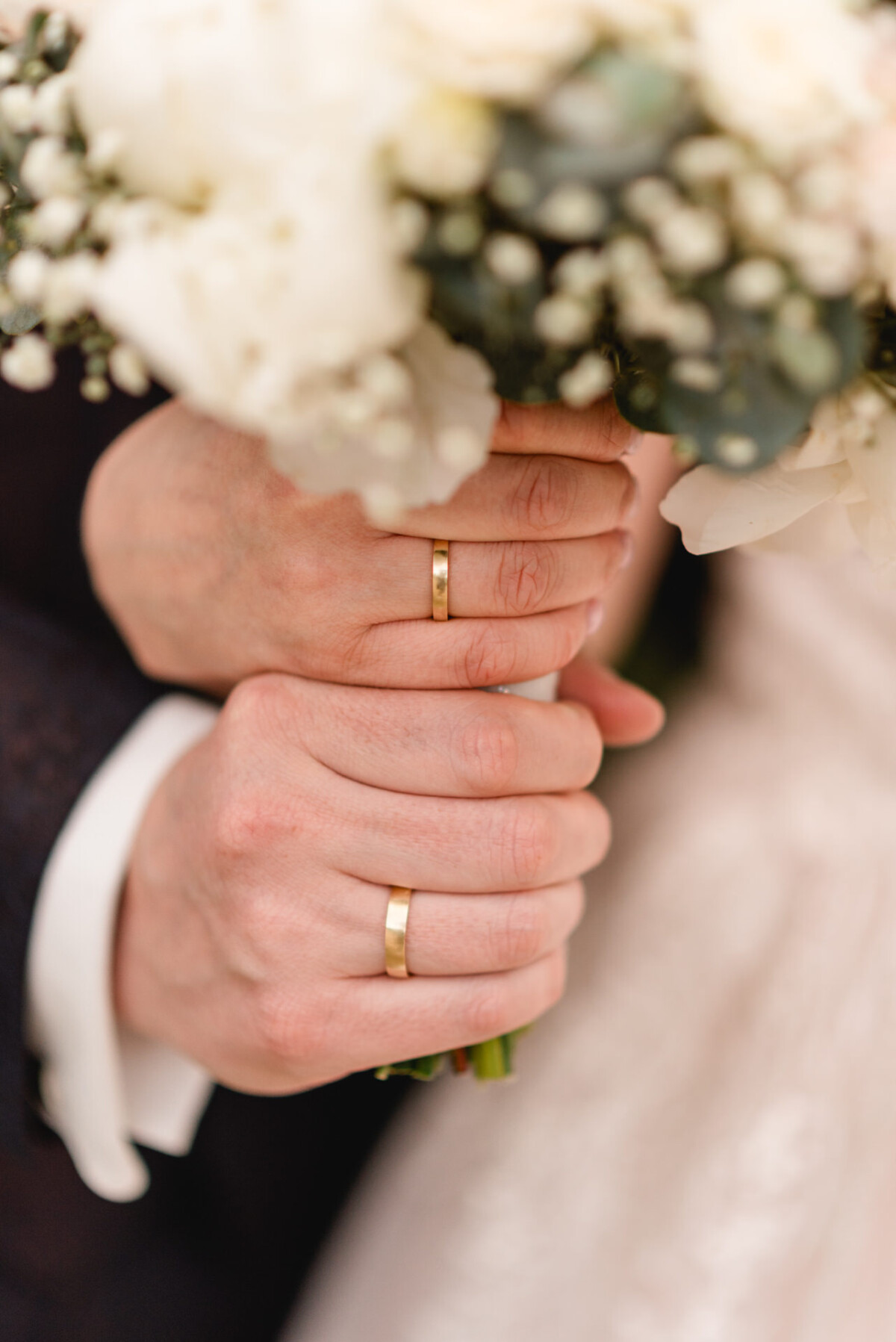 christian-lorenz.net Zwei Hände mit Eheringen halten einen Strauß weißer Blumen.